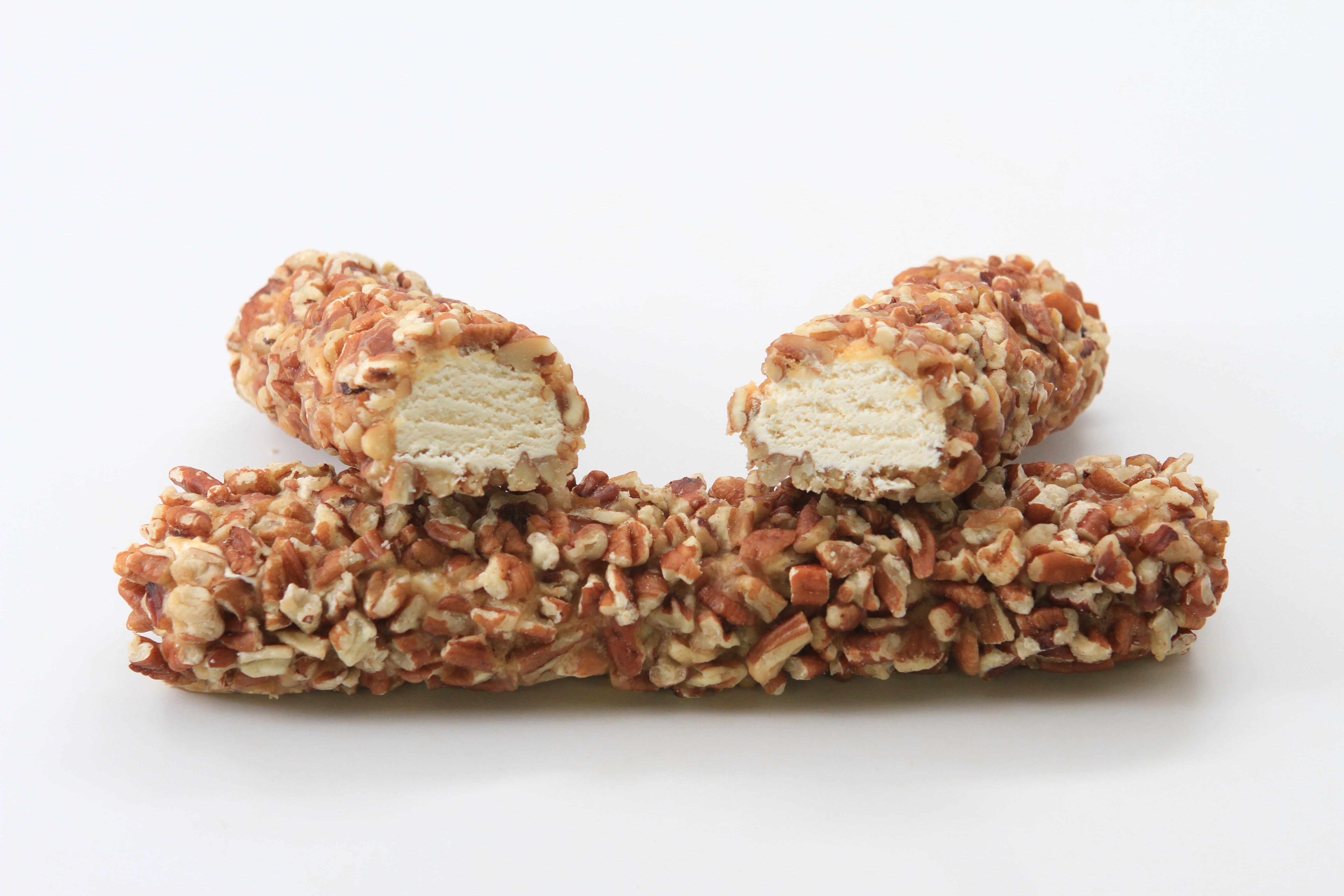 Two pecan rolls, one split in half, showing nougat filling, on top of the second