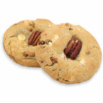 Two cookies with pecans and white chocolate chips on a white background