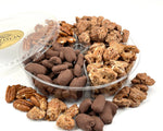 Assorted shelled pecans in a clear plastic container on a white background.