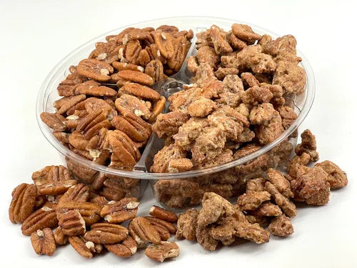 Assorted roasted pecans in a clear plastic container on a white background.
