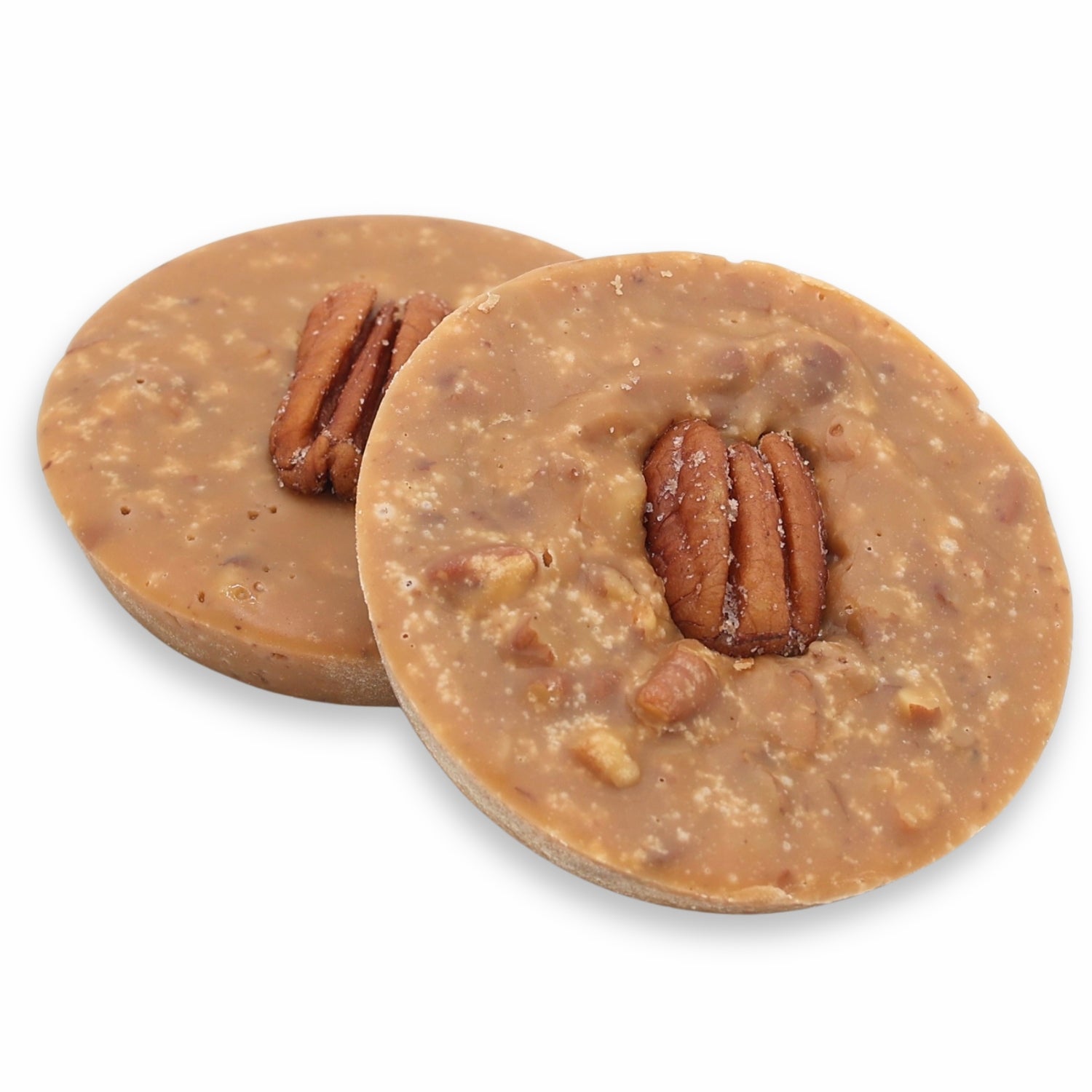 Two round pecan pralines on a white background