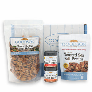 A package of Goodson Pecans Fancy Shelled Pecan Halves, a small jar of Goodson Pecans Crunchy Pecan Butter with a small jar of Goodson Pecans Creamy Pecan Butter stacked on top, a package of Goodson Pecans Toasted Sea Salt Pecans, and a Goodson Pecans box against a white background.