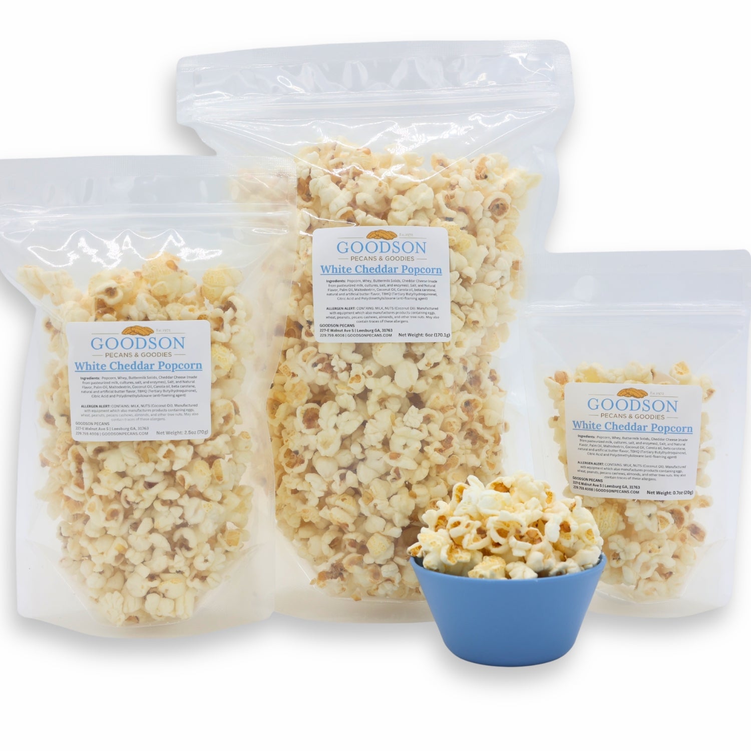 Goodson White Cheddar Popcorn in clear packaging of varying sizes with a small blue bowl of popcorn.