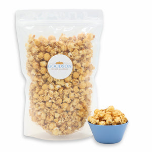 Clear 14oz bag of popcorn with a Goodson label, accompanied by a small blue bowl of popcorn on a white background.