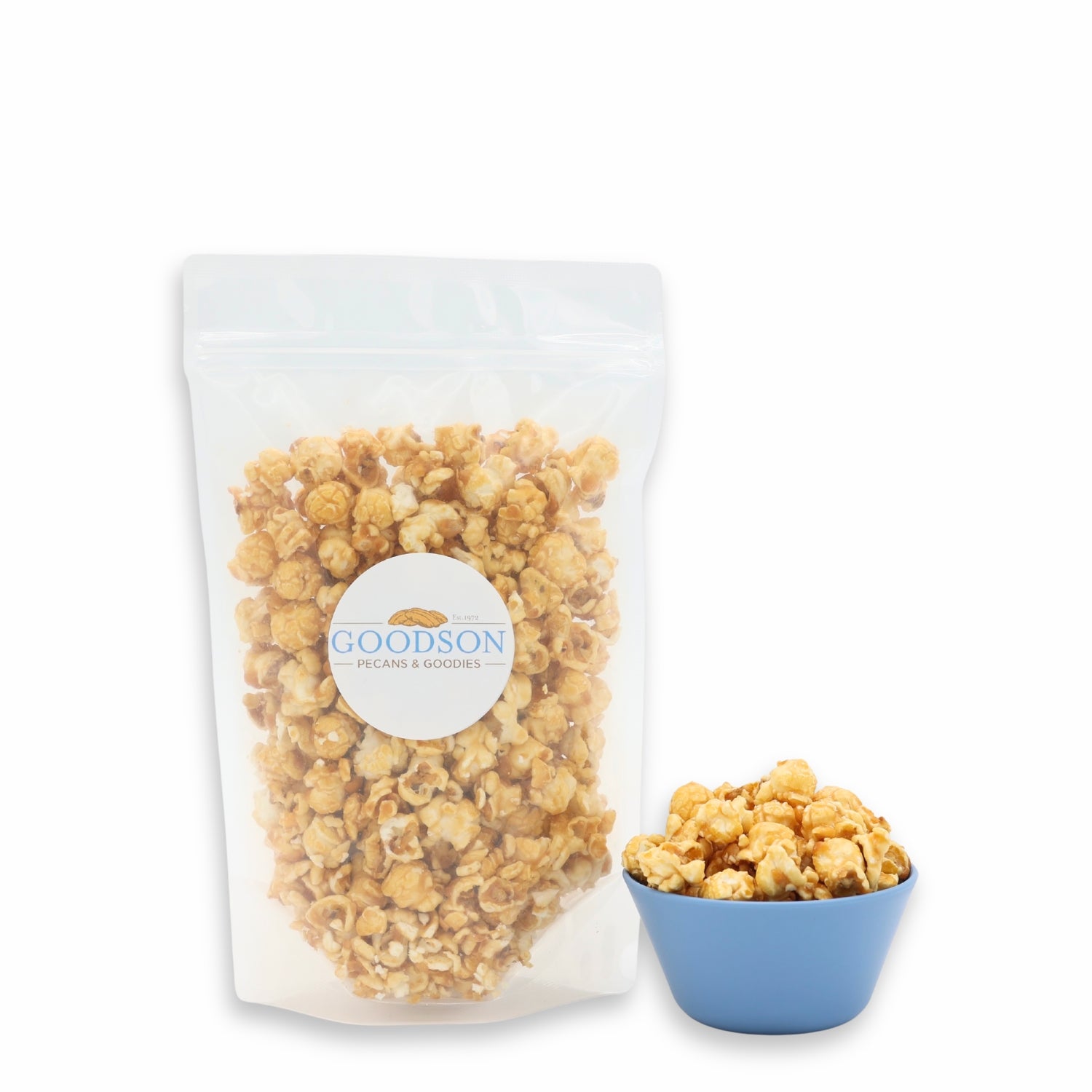 6oz bag of caramel popcorn with a Goodson label next to a blue bowl filled with popcorn on a white background