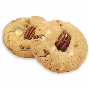 Two cookies with pecans and white chocolate chips on a white background