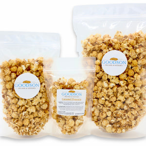 Three bags of varying sizes of Goodson Caramel Popcorn on a white background