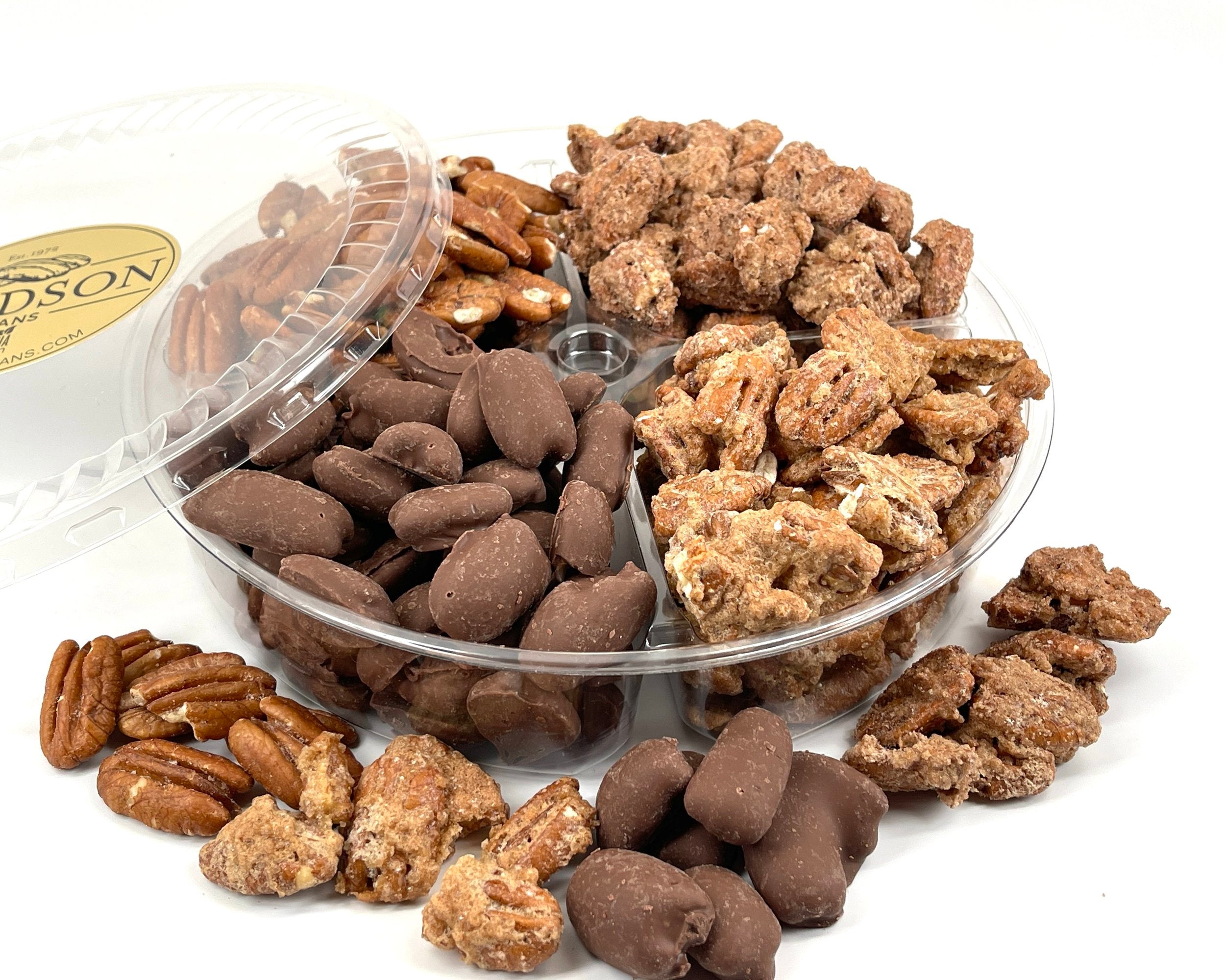 Assorted shelled pecans in a clear plastic container on a white background.